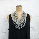 Grey brick coloured rubber chain necklace on a display model.