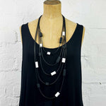 Multi strand necklace with black and white tiles along each strand