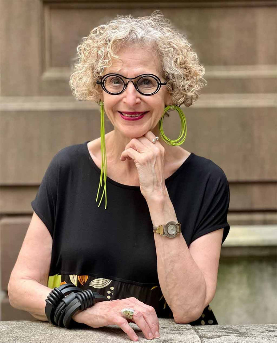 woman wearing asymmetric green rubber earrings