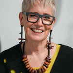 woman wearing a wooden pebble dangling earrings and necklace