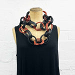Tan and black recycled rubber long necklace on a mannequin