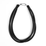 black triple strand rubber, modern necklace by Frank Ideas on a white background