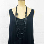 Multi strand necklace with black plastic beads on a headless mannequin