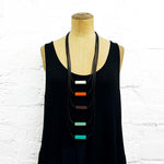 Long drop necklace with orange, brown and blue block details on a mannequin