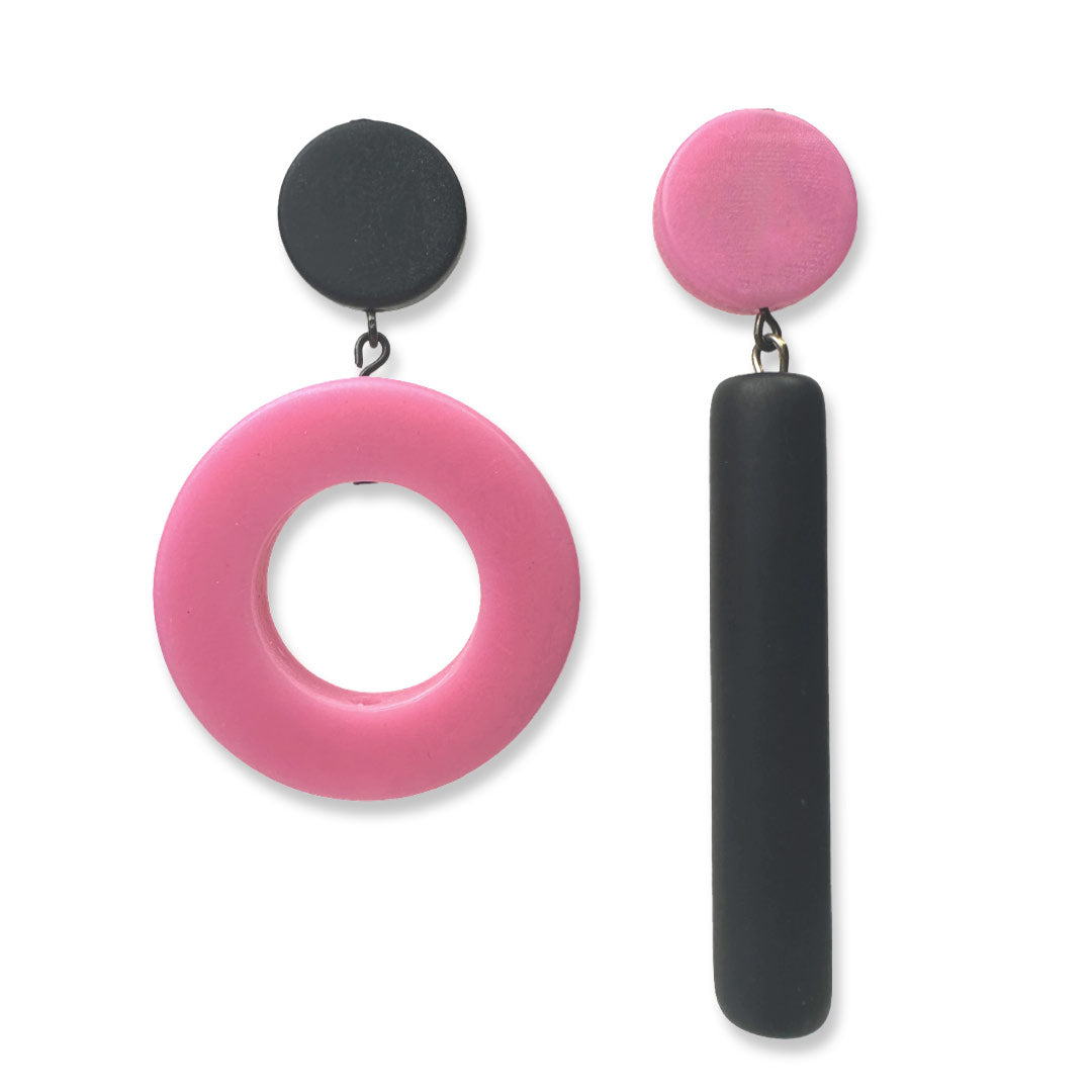 Asymmetrical black and pink dot and dash earrings on a white background