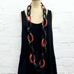 Tan and black recycled rubber long necklace on a mannequin