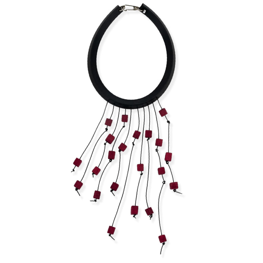 Statement necklace with red dangles on a white background