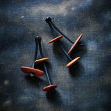 wooden pebble dangling earrings on a dark background