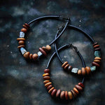 three wooden pebble necklaces on a dark background