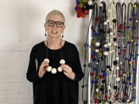 Jewellery designer Rowan Shaw wearing and showing the chunky 5 felt bead necklace
