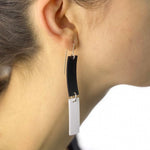 Black and White Dangle rubber earrings on a girls ear