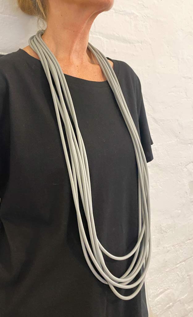 woman wearing a long grey rubber necklace