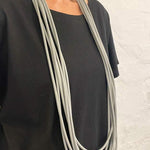woman wearing a long grey rubber necklace