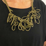 woman wearing a green statement necklace
