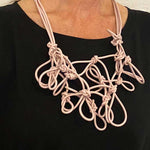 woman wearing a pink statement necklace