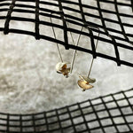 silver earrings with round silver disks on a net backdrop