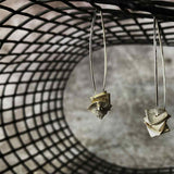 silver drop earrings with silver square disks on a net backdrop