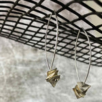 silver drop earrings with silver square disks on a net backdrop