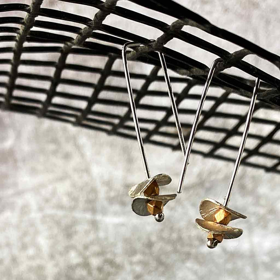 silver earrings with round silver disks on a net backdrop