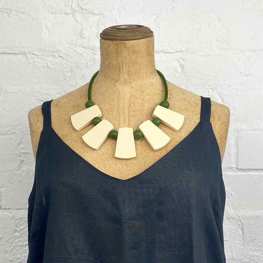 green and cream warrior necklace on a neck mannequin