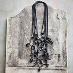 long black rubber necklace on a stone backdrop