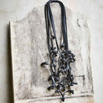 black knotted rubber necklace long black rubber necklace on a stone backdrop