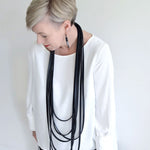woman wearing a long layered rubber necklace