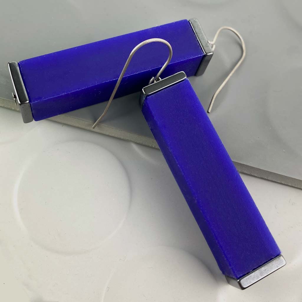 blue tower earrings on a white and grey backdrop