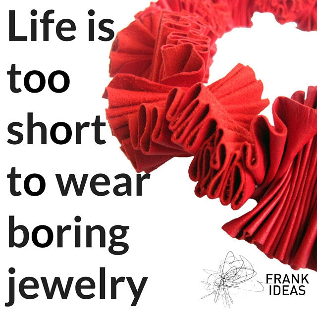 A red ruffle collar necklace with text writing to the left to say life is too short to wear boring jewellry