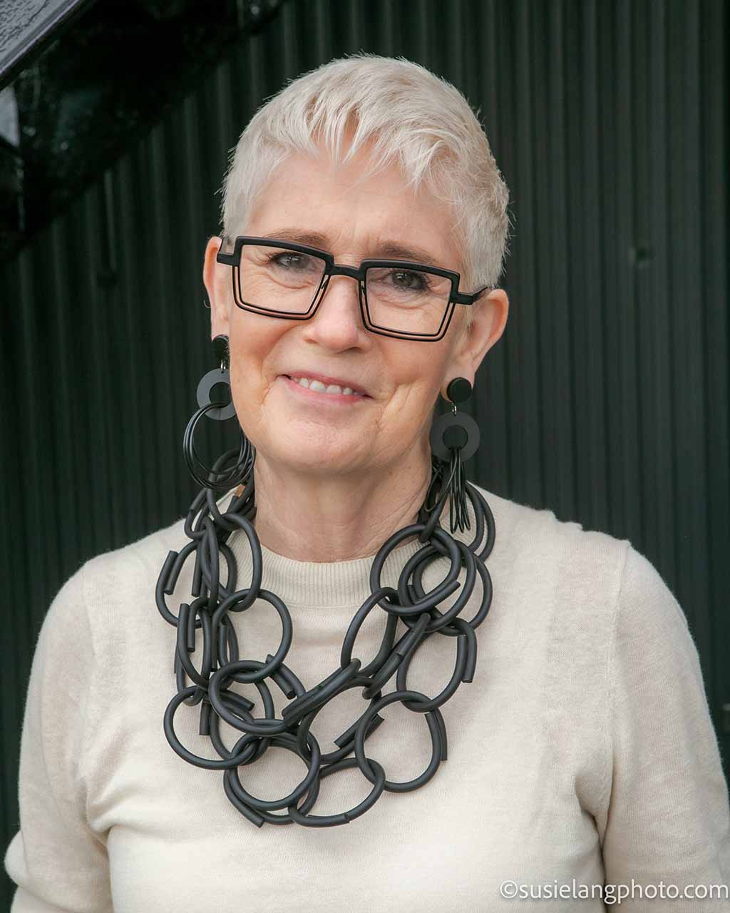 Hanging Rubber Necklaces on display on wooden wall