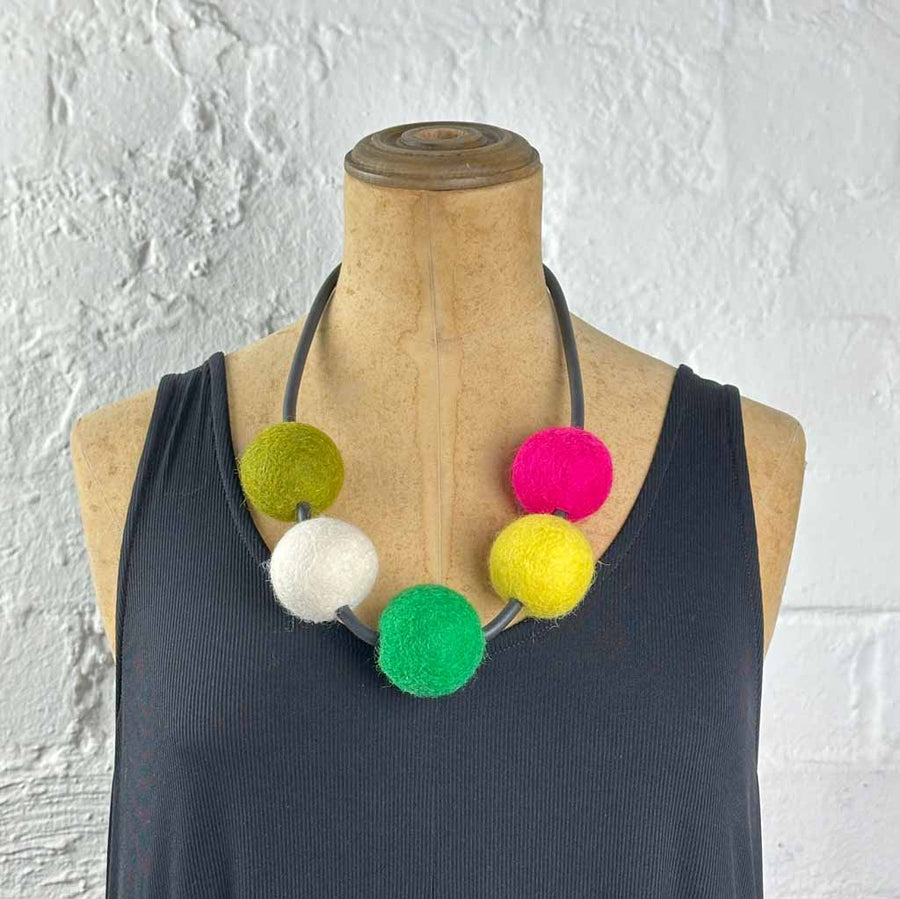 multi-colored 5 felt bead necklace on a mannequin. colors: moss green, white, mint green, yellow, magenta
