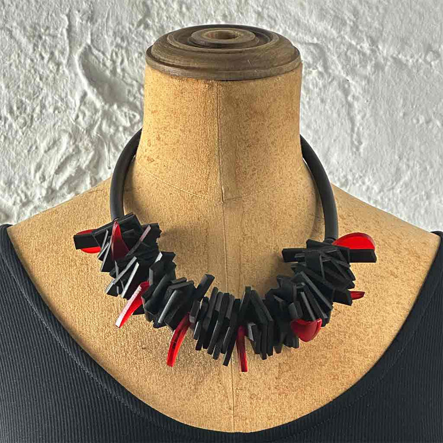 Black and red structured necklace on a neck mannequin