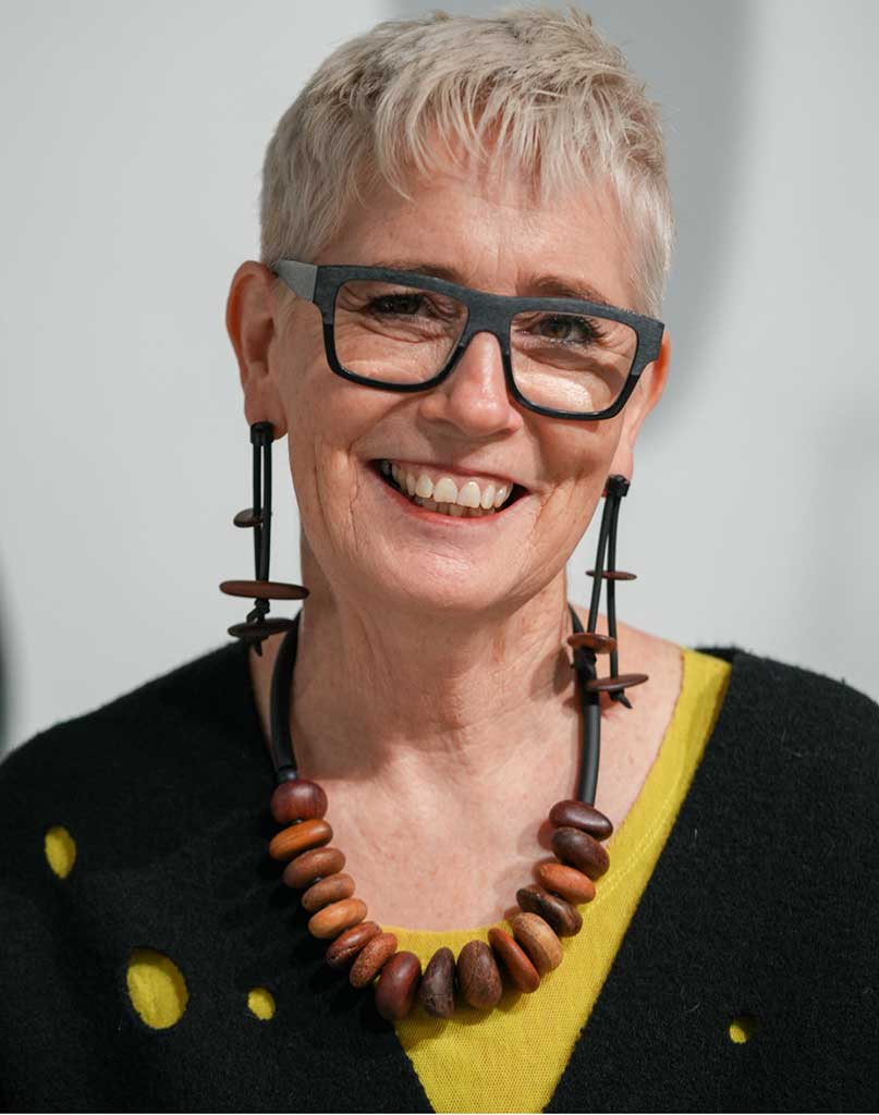 woman wearing a wooden pebble dangling earrings and necklace