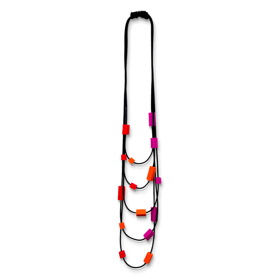 Multi strand necklace with red and. pink plastic beads on a mannequin