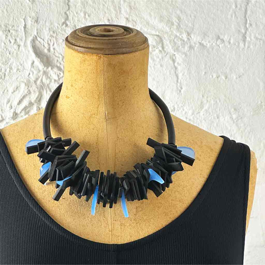 Black and blue structured necklace on a neck mannequin