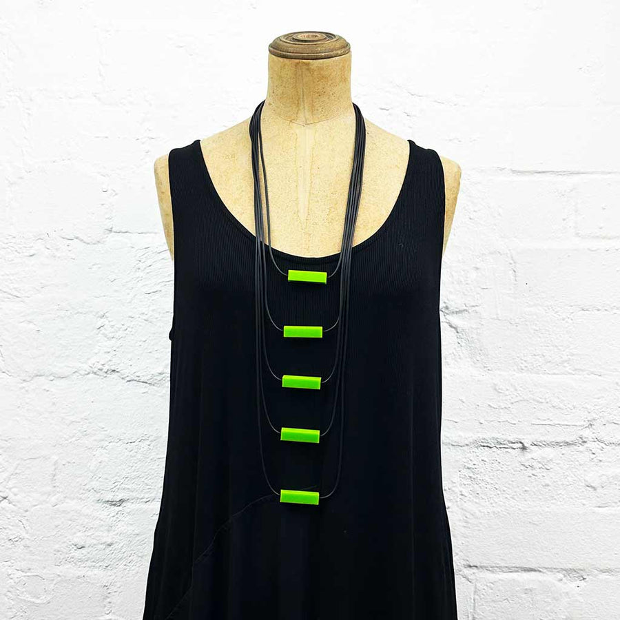 Long drop necklace with lime green small blocks displayed on a headless wooden mannequin