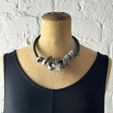 greyish-beige rubber tangled necklace on a mannequin