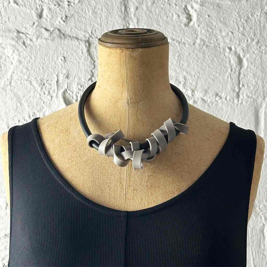greyish-beige rubber tangled necklace on a mannequin