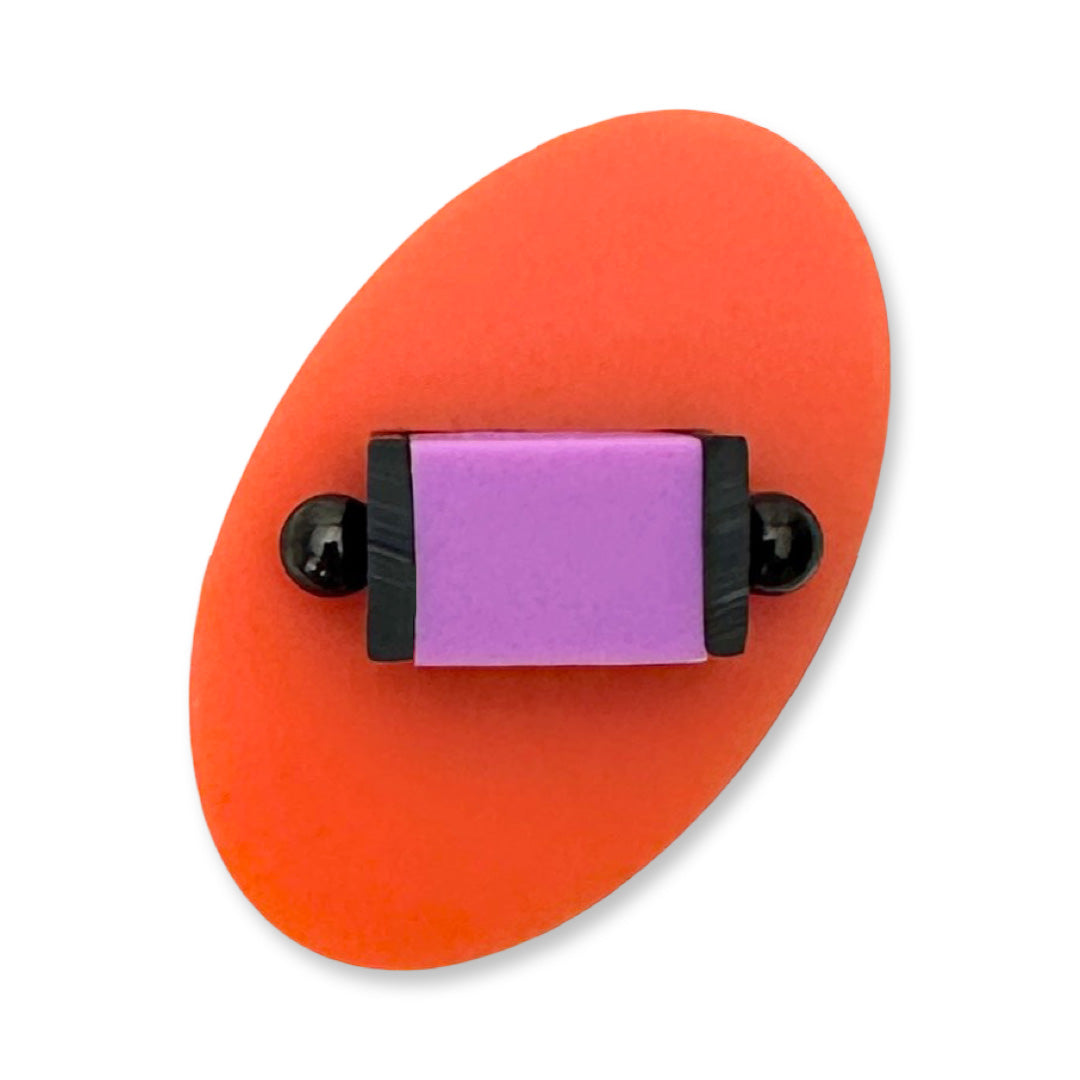 Orange oval ring with a purple square and black circular elements in the centre 