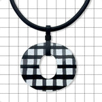 Close-up of gloss black and white gingham Perspex O pendant by Frank Ideas
