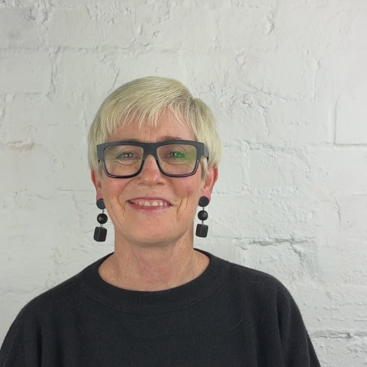 woman wearing a black dangling earrings demonstration in a video
