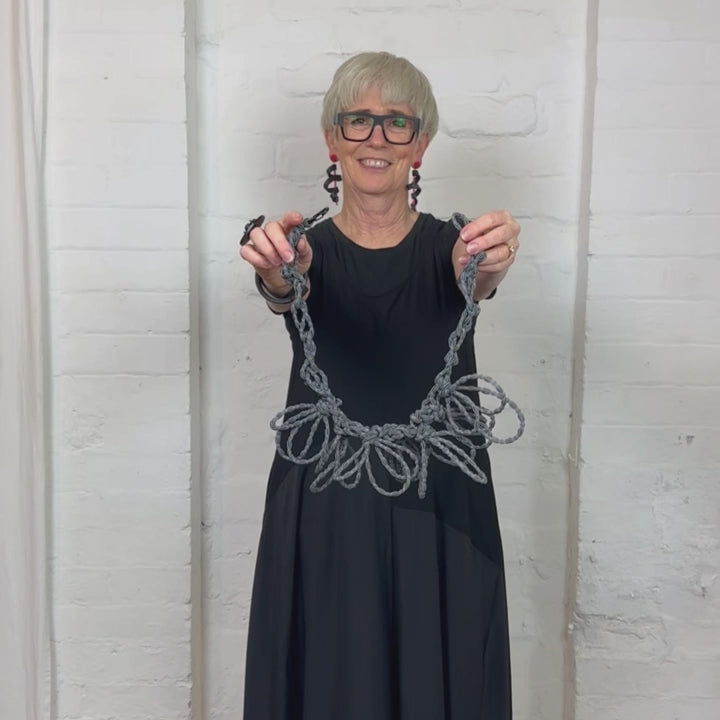 black and white textile necklace demonstration in a video