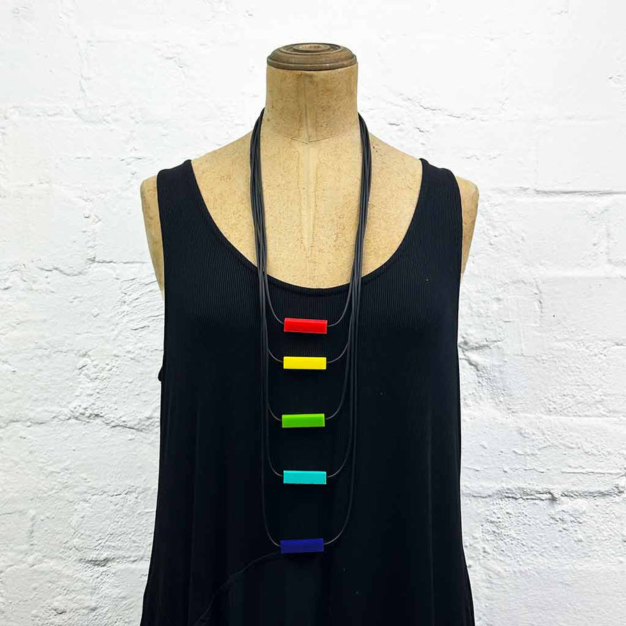 Long drop necklace with brightly coloured small blocks displayed on a headless wooden mannequin 