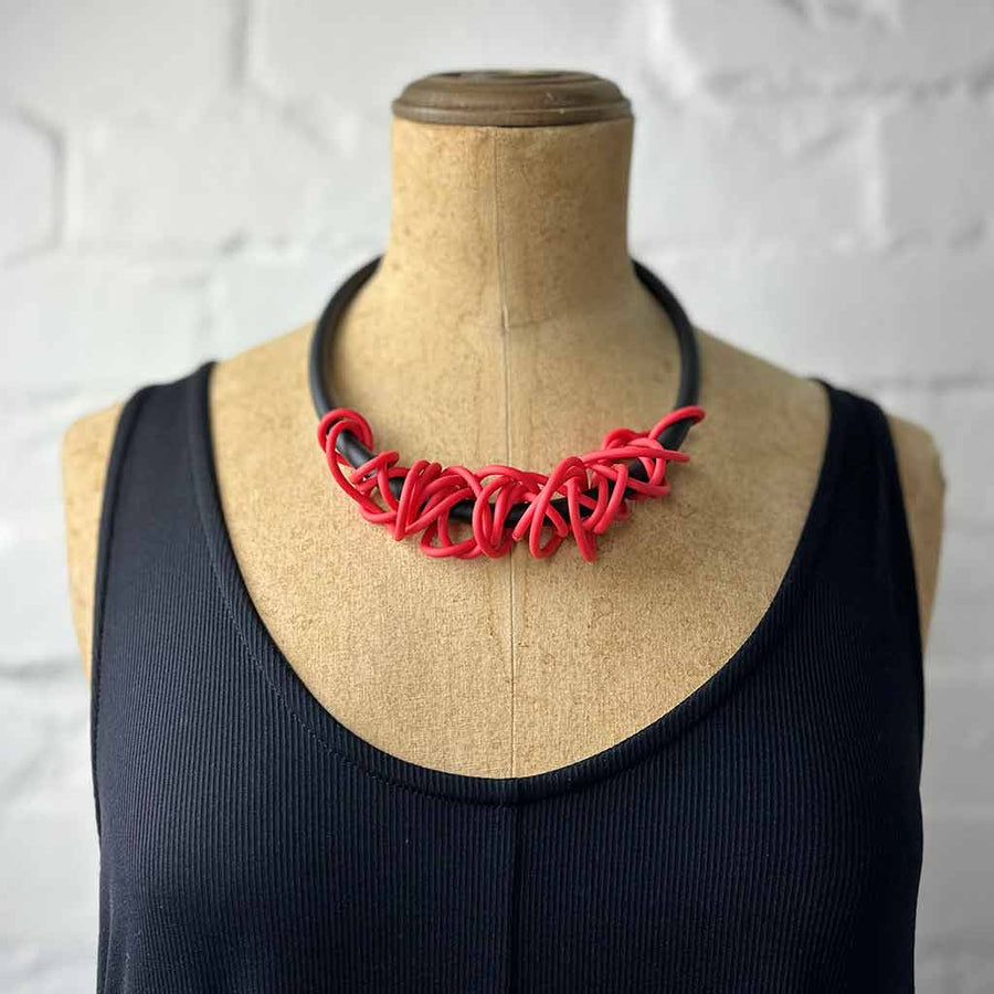 red tangled necklace on a mannequin