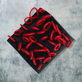 red and black rubber brooch with loops