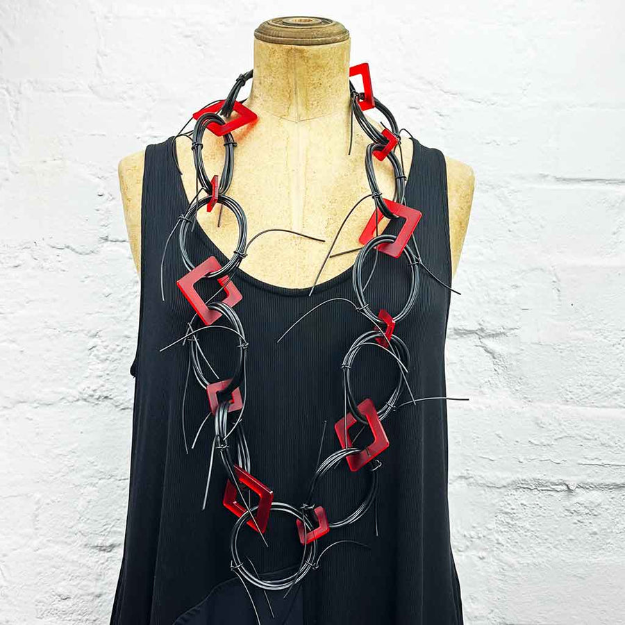 Long chaotic necklace recycled materials with red squares and black rubber o rings