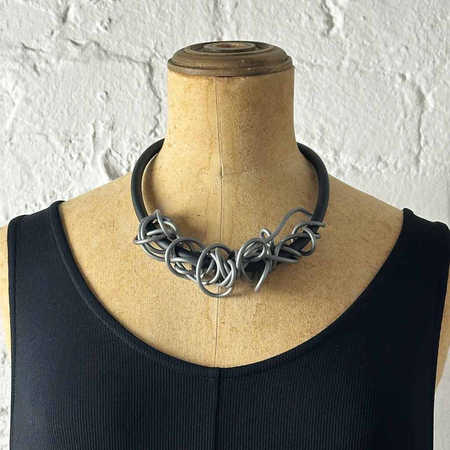 silver-coloured tangled necklace on a mannequin
