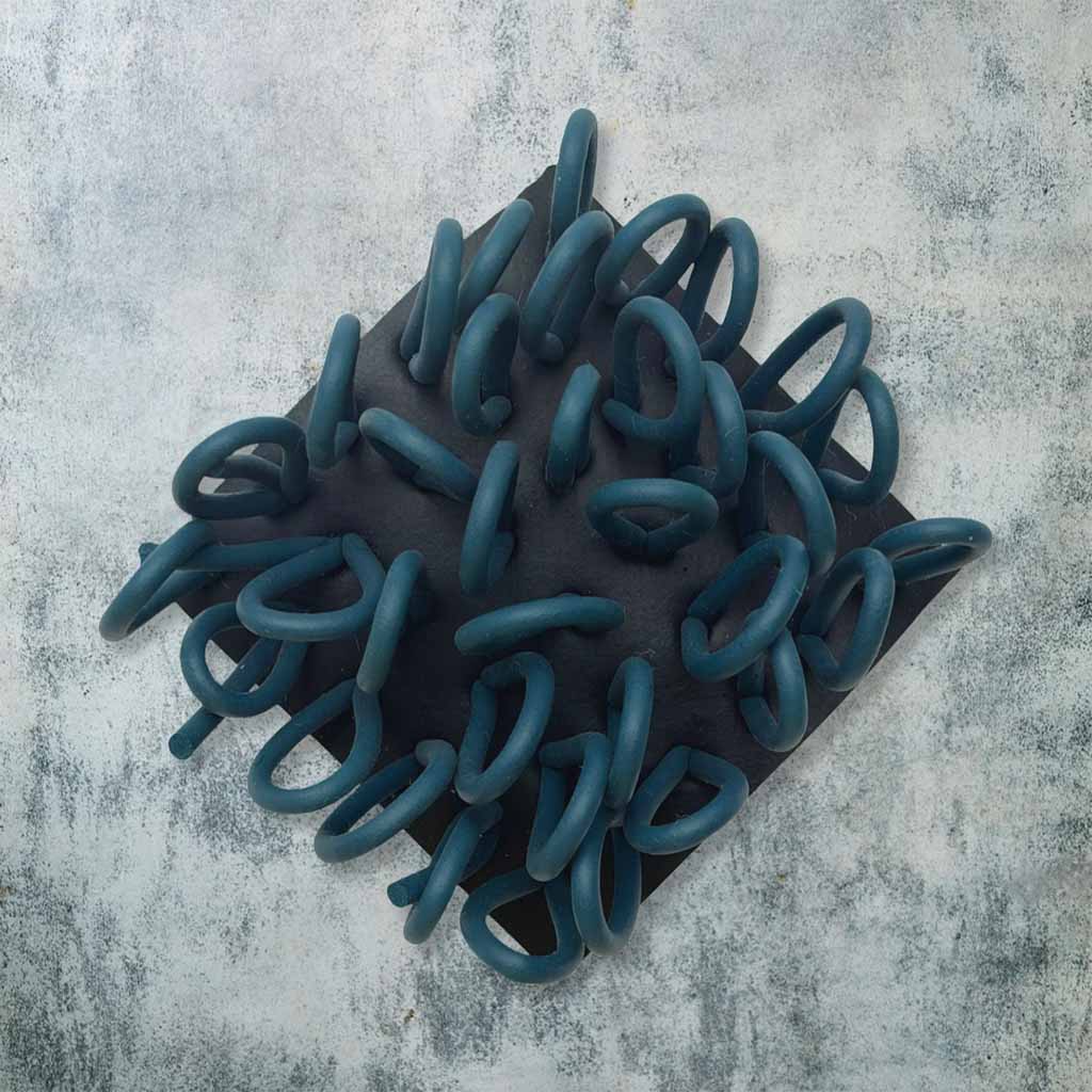black and teal rubber brooch with loops