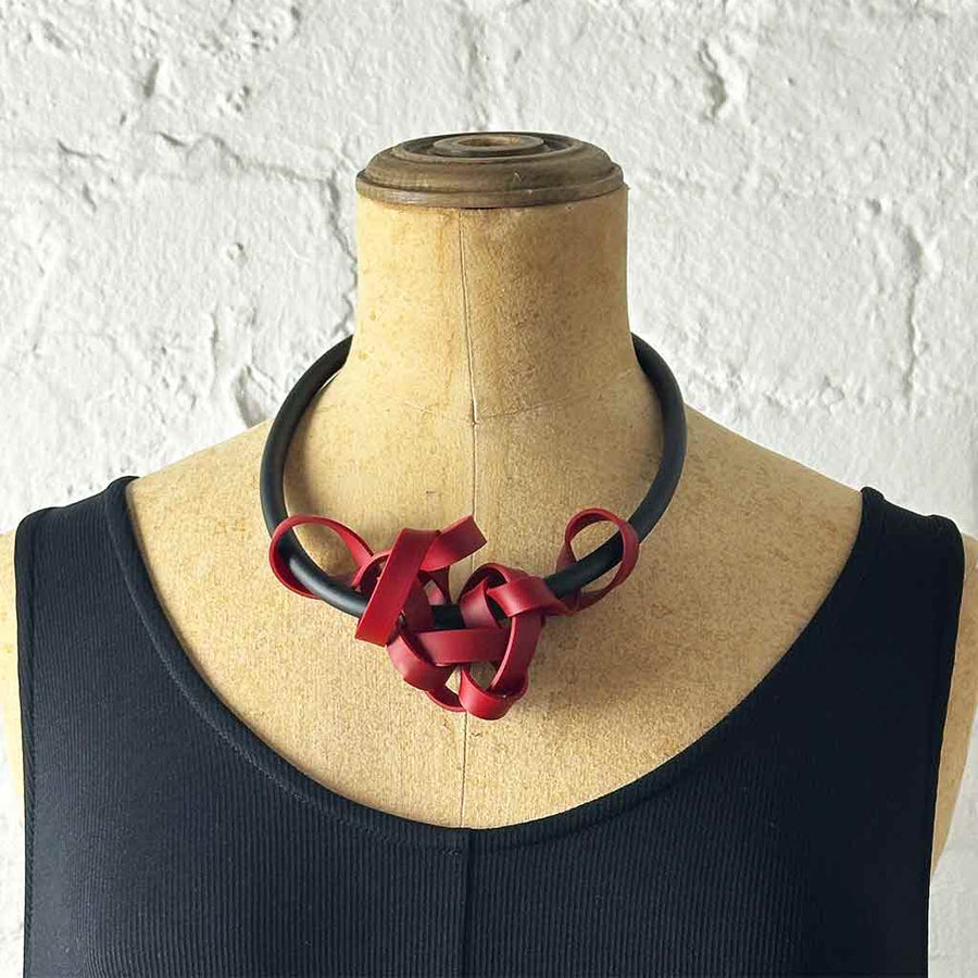 red rubber tangled necklace on a mannequin
