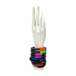 Colourful rubber bangles on a white mannequin hand against a white background